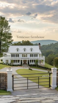 a large white house sitting on top of a lush green field