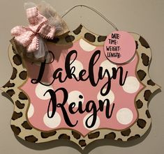 a wooden sign that says lakelyn reign with a pink bow on the top of it