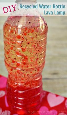 a plastic bottle filled with liquid sitting on top of a red table cloth covered in hearts