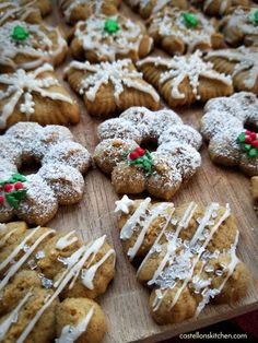 cookies with icing and sprinkles are arranged on a wooden cutting board