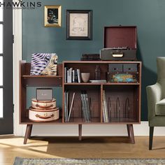 a living room with a bookcase, chair and pictures on the wall above it