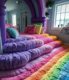 a rainbow colored bed with pillows and blankets