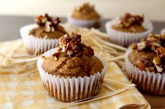 three muffins with nuts on top sitting on a table