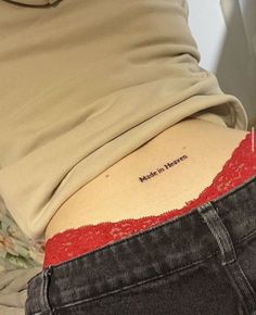 the back of a woman's stomach with her name written on it and red lace