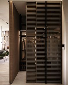 an open closet with wooden slats and sliding doors in the middle, leading to a dining room