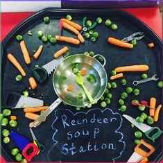 a tray with carrots, peas and other vegetables on it that says reindeer soup station