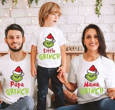 two adults and a child wearing matching t - shirts with the words little grinch on them