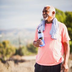 an older man holding a water bottle and smiling