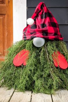 a christmas decoration made out of grass and red mitts