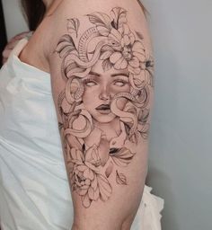 a woman's face with flowers and leaves on her arm, in black and white