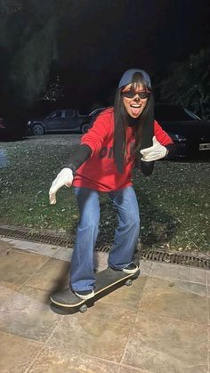 a woman riding a skateboard down the side of a sidewalk