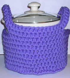 a purple crocheted pot holder with a glass lid on a white counter top