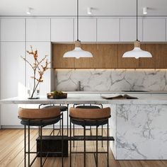 a kitchen with marble counter tops and stools in front of an island that has two lights hanging over it