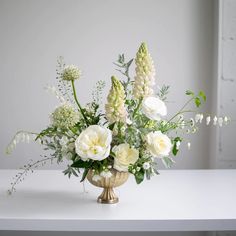 a vase filled with white flowers on top of a table