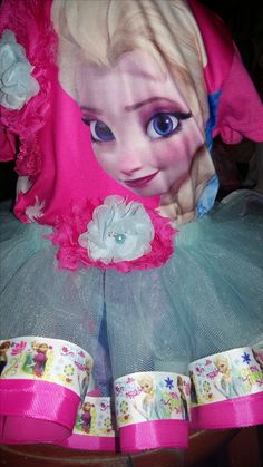 a child's dress made to look like a doll with blue eyes and pink hair