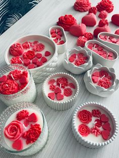 several heart shaped cupcake tins on a table with hearts and flowers in them