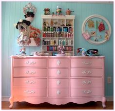 a pink dresser with lots of toys on top