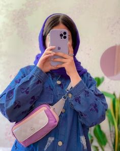 a woman taking a selfie with her cell phone in front of her face and wearing a blue jacket