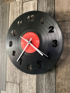 a clock that is on the side of a wooden wall with numbers and times in it