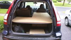 the back end of a car with an open hatchback and wooden table in it