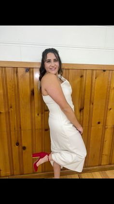 a woman in a white dress and red heels posing for the camera with her hands on her hips