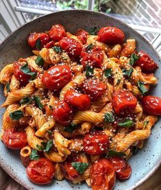 a bowl filled with pasta covered in tomato sauce