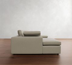 a couch sitting on top of a hard wood floor next to a white wall and wooden floor