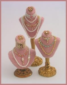 three pink mannequins with pearls and jewels on them