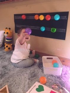 a toddler playing with some balls on the floor