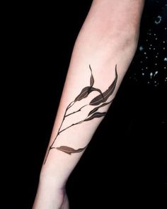 a woman's arm with a branch tattoo on the left side of her arm