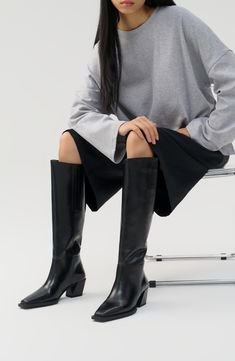 Elevate cool-weather ensembles with this knee-high boot highlighted by a Western-inspired stacked heel and square toe. 2 1/4" heel 17 1/4" shaft Pull-on style Leather upper and lining/synthetic sole Imported Women's Shoes Sleek Knee-high Boots With Stacked Heel And Square Toe, Vagabond Knee High Boots, Sleek Calf Leather Knee-high Boots With Square Toe, Boots 2024 Trend, Vagabond Alina Boots, Mid Calf Boots Outfit, Black Knee-high Boots With Sculpted Heel And Wide Calf, Calf Boots Outfit, Black Knee-high Calf Leather Boots With Sculpted Heel