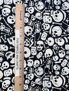 a ruler is next to a black and white background with skulls, bones and crosses