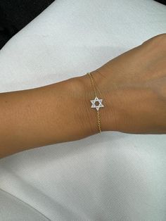 This elegant Star of David bracelet features a dainty design with a sparkling diamond accent, crafted in 14K gold. Its delicate yet durable chain adds a touch of sophistication, making it perfect for everyday wear or special occasions. The Star of David symbolizes faith and protection, making this piece a meaningful addition to your jewelry collection or a thoughtful gift for a loved one. Ideal for celebrating Jewish heritage with style and grace, this bracelet blends tradition with modern elegance. Star Of David Bracelet, Jewish Heritage, Jewish Jewelry, Religious Symbols, Sparkling Diamond, Wedding Jewelry Bracelets, Star Of David, Style And Grace, Wedding Bracelet