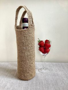 strawberries in a wine glass next to a crocheted bag