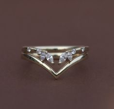 a gold ring with three pear shaped diamonds on the top and two smaller pears in the middle