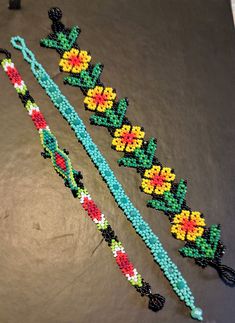 three beaded bracelets sitting on top of a table next to each other,