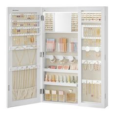 an open white cabinet filled with lots of jewelry