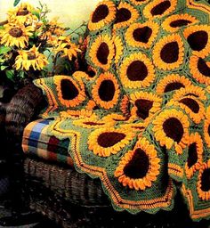 a couch covered in sunflowers with a blanket on it