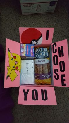 an open box with candy and other items in it that says i choose you, pikachu