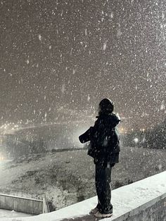 a person standing on top of a snow covered roof