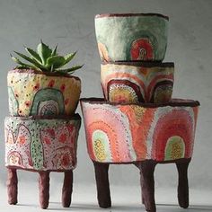 three potted plants sitting next to each other on top of stools with wheels