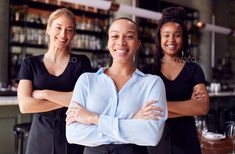 three women standing in front of a bar with their arms crossed - stock photo - images