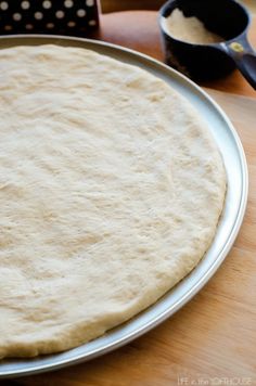 an uncooked pizza dough is on a pan