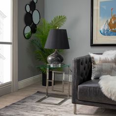 a living room with a couch, lamp and pictures on the wall in it's corner