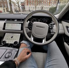 a man is sitting in the driver's seat of a car with his hands on the steering wheel