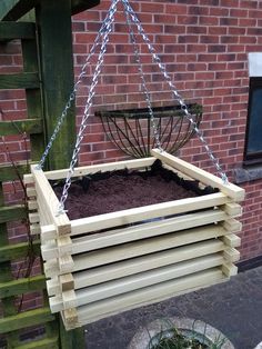 a wooden swing hanging from the side of a brick building