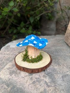 a small blue mushroom sitting on top of a tree stump