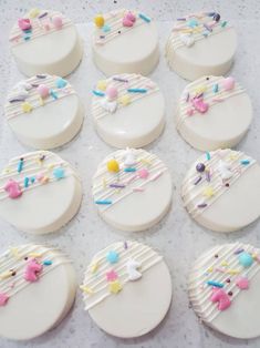 twelve decorated cookies sitting on top of a table