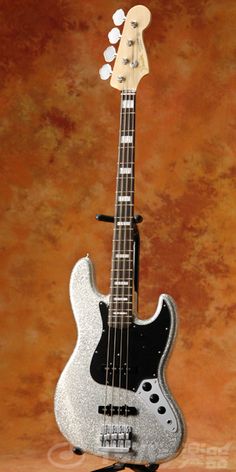 a silver and black guitar sitting on top of a table