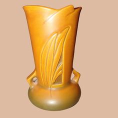 a yellow vase sitting on top of a table